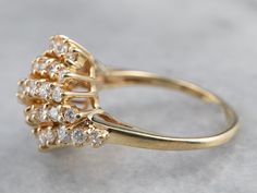 Many small parts create the whole in this vintage diamond ring. These diamonds have excellent color, and arranged together this way they form a sweet linear cluster in one sparkling profile! This fantastic vintage piece is crafted of highly polished yellow gold and is ready to wear or gift! Metal: 14K Yellow Gold Gem: 45 Diamonds totaling 2.92 Carats, G in Color, SI1 in Clarity Gem Measurements: 3.1 mm, Round (center stone) Ring Size: 7.25 Cluster Yellow Gold Diamond Ring With Prong Setting, Yellow Gold Cluster Diamond Ring With Prong Setting, Classic Yellow Gold Cluster Diamond Ring, Cluster Diamond Ring With Prong Setting, Yellow Gold Diamond Cluster Ring, Vintage Yellow Gold Cubic Zirconia Cluster Ring, Cocktail Ring Diamond, Yellow Gold Sapphire Ring, Vintage Diamond Ring