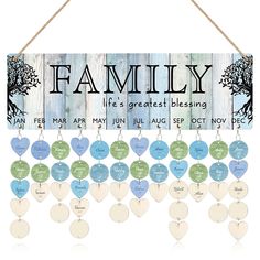 a family sign hanging on a wall with hearts and tree names in blue, green and white