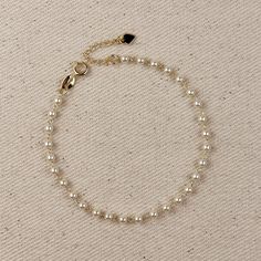 Offrez-vous une élégance intemporelle avec notre bracelet de perles de 3 mm en or 18 carats. Fabriquée avec de délicates perles simulées, cette pièce classique ajoute une touche de sophistication à toutes vos tenues. Rehaussez votre style et adoptez la sensation luxueuse de cet élégant bracelet. * Métal : or 18 carats * Largeur : 3 mm de perles simulées * Tailles :  6,5 pouces de long + 1 pouce d'extension 7,25 po. de long + chaîne d'extension de 1 po. * Hypoallergénique * Résistant à l'eau * Fabriqué à la main au Brésil Hand Chain Bracelet, Paris Jewelry, 18k Gold Chain, Stacked Earrings, Bracelet Metal, Gold Filled Ring, Elegant Bracelet, Emerald Jewelry, Anklet Jewelry