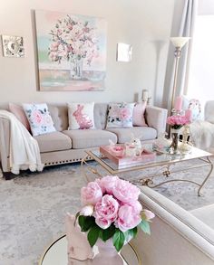 a living room filled with furniture and pink flowers