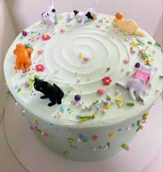 a white cake with sprinkles and cats on it