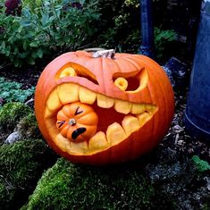 a pumpkin carved to look like a cat's face is sitting on the ground