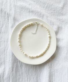 "Photo 2 shows the 16\" length option. Freshwater pearls are one of a kind so each necklace will be entirely unique and will differ from those shown in the photos.  ∙ S I Z E ∙ G U I D E ∙ The below is a rough size guide for adults. We recommend taking your own measurement first before purchasing to ensure the perfect fit, however, exchanges are always welcome - please see our Shop Policies.  14\" - choker length 16\" - collarbone length  18\" to 20\" - upper chest length  20\" to 22\" - chest length Each necklace comes with an additional 2\" extension chain, for example, if you select the 14\" option, the total length of the necklace including the extension chain will be 16\".   M A T E R I A L S ∙    Durable steel cord, genuine freshwater pearls, silver plated or sterling silver clasp an Adjustable Pearl Necklace With Sterling Silver Clasp, White Pearl Necklaces With Sterling Silver Clasp, Adjustable Delicate Baroque Pearl Necklace, Minimalist Single Strand Baroque Pearl Necklace, Adjustable Baroque Pearl Necklace, Minimalist White Baroque Pearl Necklace, Adjustable Single Strand Baroque Pearl Beaded Necklaces, Adjustable Baroque Pearl Necklace In Pearl White, White Pearl Necklace With Adjustable Sterling Silver Clasp