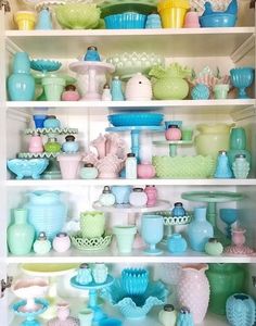 a shelf filled with lots of different colored vases and bowls on top of each other