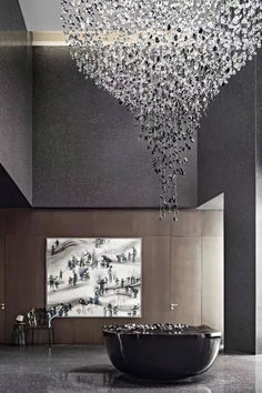 a large crystal chandelier hanging from the ceiling in a room with black walls