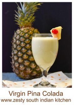 a pineapple drink in a glass next to a pineapple on a napkin with the caption virgin pina cola