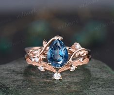 a ring with an oval blue topazte surrounded by white diamonds on a rock