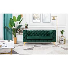 a living room with green velvet couches and potted plants