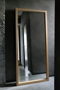 a mirror that is sitting on the ground in front of a wall with a door