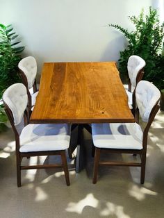 a wooden table with white chairs around it