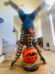 a scarecrow is sitting on top of a pumpkin