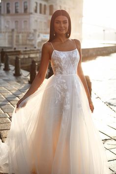 a woman in a white dress standing on the street