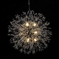 a chandelier hanging from the ceiling in a dark room with lights on it