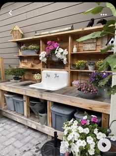 an outdoor kitchen with potted plants and sink