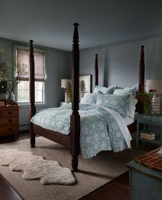 a bedroom with four post bed and blue walls