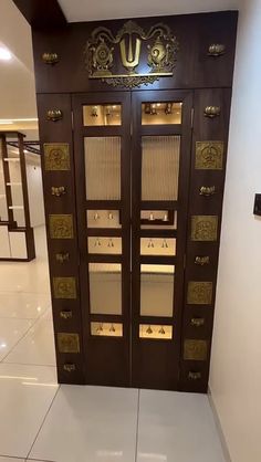 two brown doors with gold handles in an empty room and white floor tiles on the ground