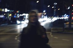 a blurry photo of a person walking down the street at night