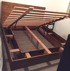 the bed frame is made out of wood and has no mattresses or sheets on it