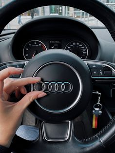 a person is holding the steering wheel in their car while it's being driven