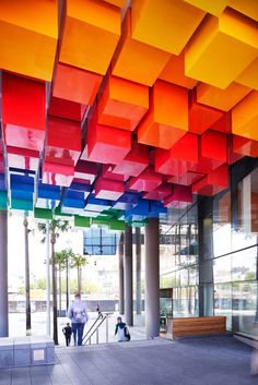 people are walking in front of a multicolored ceiling