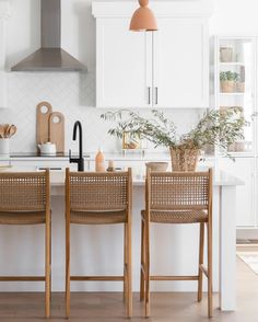 two wooden chairs sitting at a kitchen island