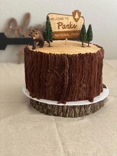 a cake that is sitting on top of a wooden stump with the words parko carved into it