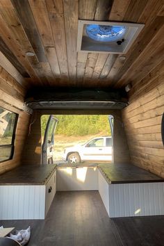 the inside of a small camper with wood paneling on the walls and ceiling