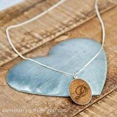 a necklace with a wooden heart and the letter d hanging from it's side