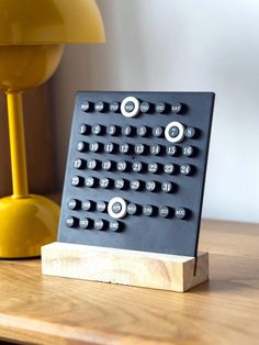 a remote control sitting on top of a wooden table next to a yellow lampshade