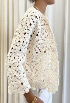 a woman wearing a white crochet shawl with an openwork pattern on it