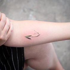 a woman with a small arrow tattoo on her arm