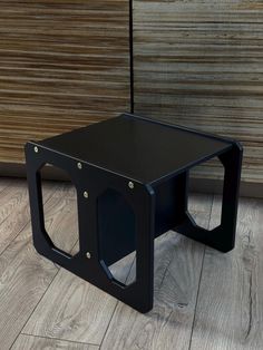 a black table sitting on top of a wooden floor