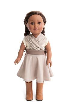 an american girl doll wearing a white dress and brown shoes, with braids on her hair