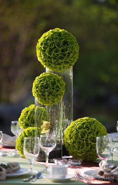 the centerpieces are filled with green flowers and greenery, along with wine glasses