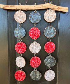 a group of red, white and blue circles hanging from a wooden door with chains attached to it