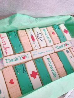 a box filled with lots of decorated cookies in the shape of nurse's notes