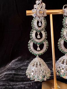 Gorgeous Handmade Statement Long Earrings in American Diamond in Sliver Color with Green Stones on all the corners and a hanging Pearl. Light Weight with back support. Item : Earring Set Color : Sliver and GreenLength of Earrings : 3.5 inches Width of Earnings - 1 inches (widest part)Circumference of the Jumka on the bottom - 4 inches Shop Polices -- Final Sale, No Return, No exchange - Please note Jewelry is delicate and Fragile, please handle with care.- There can be little variation in the co Silver Chandbali Pierced Jewelry, Silver Latkans Jewelry For Formal Occasions, White Hand Set Chandelier Earrings For Party, Silver Bridal Earrings With Latkans For Formal Events, Silver Pierced Chandelier Earrings For Festive Occasion, Formal Silver Jewelry With Latkans, Sterling Silver Dangle Chandelier Earrings For Festive Occasions, Sterling Silver Festive Dangle Chandelier Earrings, Green Fusion Style Party Earrings