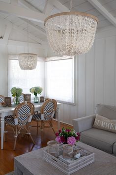 a living room filled with furniture and a chandelier hanging over it's head