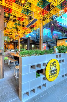 the interior of a restaurant with plants growing out of it's walls and windows