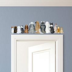 a group of small figurines sitting on top of a door way ledge in front of a blue wall