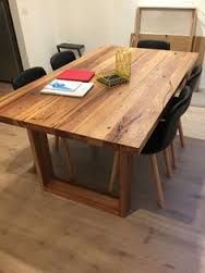 a wooden table with black chairs and a red book on it in the middle of a room