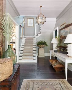 the inside of a house with stairs and rugs