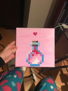 a person holding up a piece of art made to look like a video game character