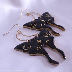 Subtle holographic shimmer accentuates the black polymer clay; gold moons are encased in resin to give strength, shine, and a professional finishing touch. These earrings are sure to make a statement and leave an impression! They measure just under 3 inches long and about 2 inches wide, hang from stainless steel crescent moons and French ear hooks. They are a medium weight, so I do not recommend them for novice earring wearers. The earrings are tough, but I do not recommend wearing in the shower 30s Clothes, Moth Earrings, Black Polymer Clay, Manifesting Board, Earrings Shein, Steampunk Costumes, Witch Crafts, Autumn Jewelry, Crafty Fox