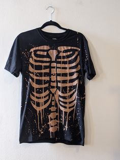 A classic bleached-out skeleton tee featuring the ribs on the front and the spine on the back. If you're a fan of this alternative goth style then this graphic tee is for you. READ THIS BEFORE ORDERING It takes 1 week to ship out due to my current workload. Message me if you need your shirt by a certain date before ordering. 100 % cotton Gildan brand, or ATC brand It can be made in size men's S-2X. Message me if you need a different size before ordering. A sizing chart is included in the images. Skeleton Shirt Design, Skeleton Bleach Shirt, Bleach Skeleton Shirt, Skeleton Tshirts, Bleach Tshirt, Skeleton Clothes, Bleaching Clothes, Bleach Hoodie, Skeleton Tshirt