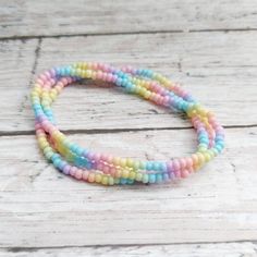 This bracelet is made from seed beads in pastel rainbow colors(bead size is 8/0 approx. 3mm beads, see picture for 3mm size reference).  This listing is for THREE stretch bracelets. The cord is a lightweight clear stretch material.  It has a mid-range pound test, so it can be easily stretched to fit over your hand and should be comfortable to wear.  Excessive or extreme stretching may cause the cord to break or become loose.  Please measure your wrist and select the size you need from the drop d Rainbow Beaded Friendship Bracelets, Rainbow Heishi Beads Bracelets For Jewelry Making, Rainbow Colorful Beads Friendship Bracelets For Jewelry Making, Pastel Beaded Bracelets With Colorful Round Beads, Adjustable Pastel Beaded Necklaces With Colorful Beads, Rainbow Beaded Bracelets With Round Beads, Pastel Rainbow Colors, Stacking Bracelets, Spring Pastels