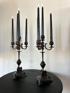 two black candlesticks sitting on top of a table