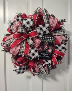 a red and black wreath hanging on the front door