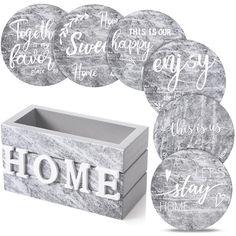 six coasters with the words home in white and black on them, sitting next to a box