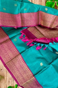 This banarasi inspired stunning kanjivaram saree in turquoise blue shot with black is handwoven with yazhi and horse motifs in gold zari on the body. The borders in magenta purple have traditional motifs like floral, chakras and geometric patterns in gold zari. The grand pallu in magenta purple color mirrors the patterns of the borders in gold zari. Approximate Length 6.5 mtrs (inclusive of blouse length) Approximate weight - 1.5 lbs Approximate Height - 48 - 52" Saree comes with fall, picot and tassels done when applicable. Blouse piece is cut. Kindly Note : The colors you see on your device may vary due to the color reproduction, brightness and resolution of individual devices. If you'd like more clarity before your purchase, please contact our support team Blue Shots, Horse Motif, Kanjivaram Saree, Kanjivaram Silk Saree, Magenta Purple, Traditional Motifs, Silk Cotton Sarees, Kanjivaram Sarees, Cotton Sarees